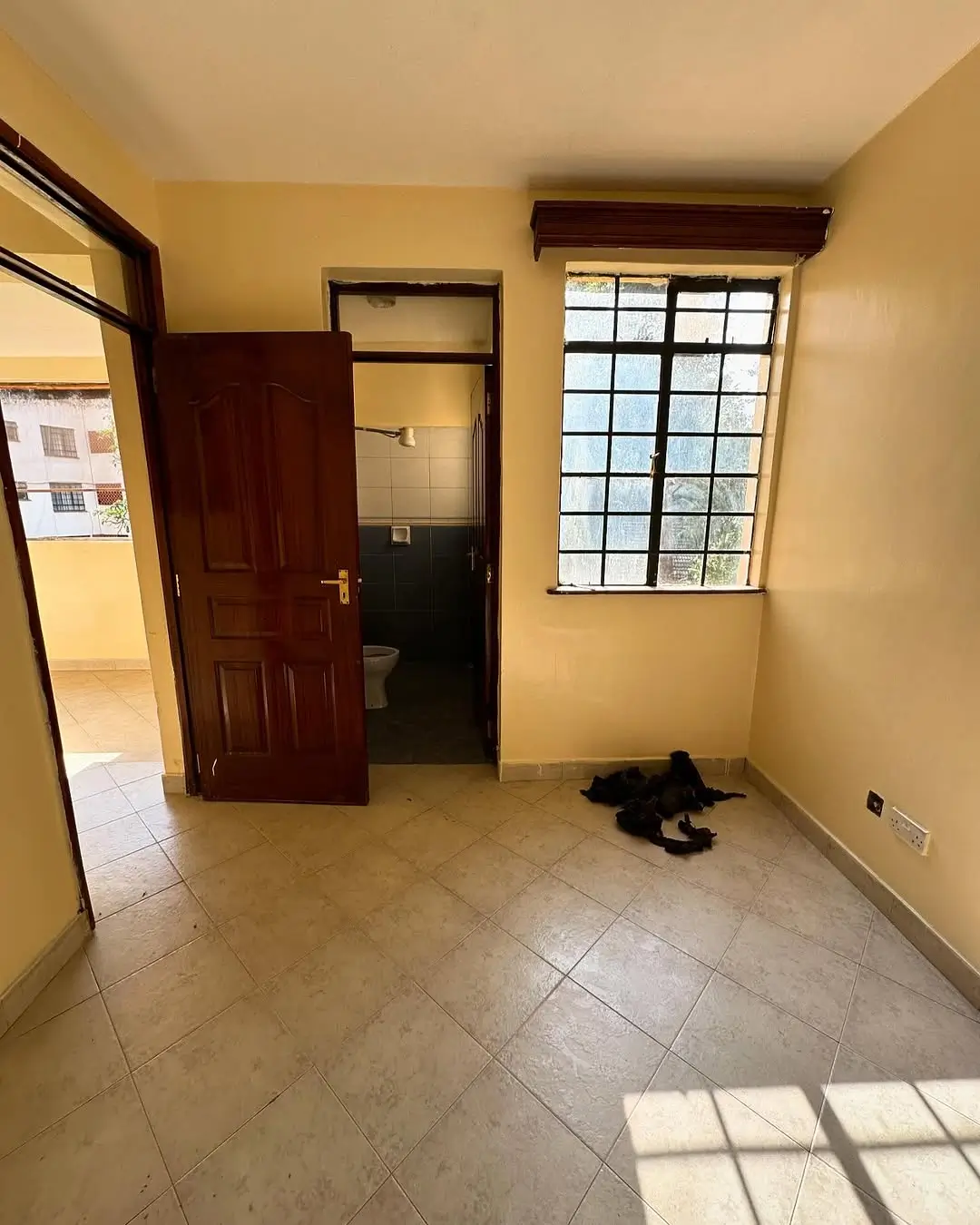 Spacious bedroom with tiled floor and natural light