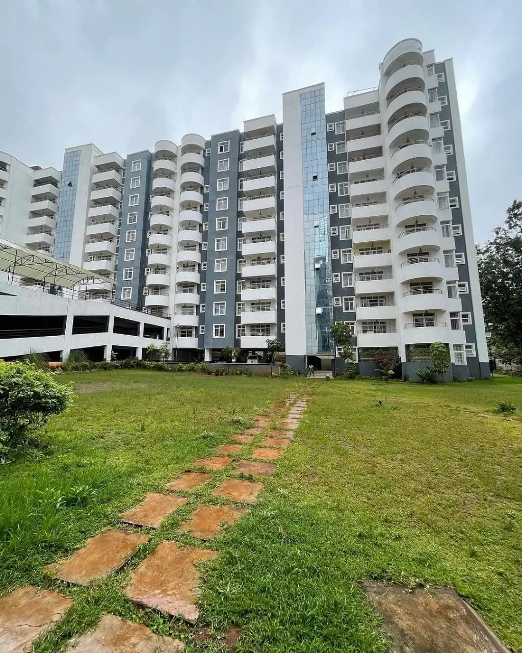 Modern multi-story residential building with manicured lawn grounds