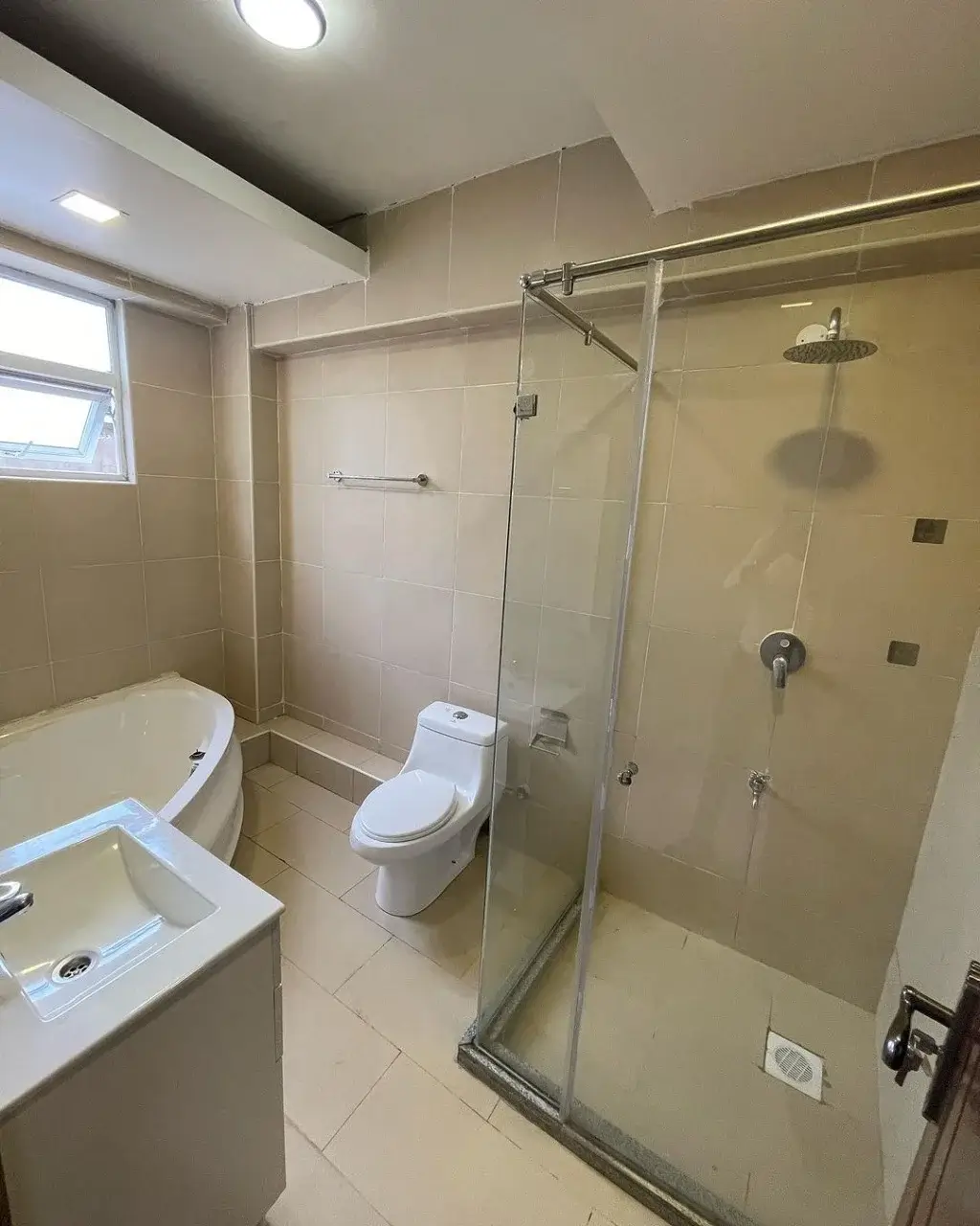 Modern bathroom with glass shower enclosure and white fixtures