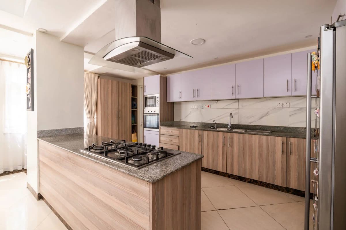 Modern kitchen with island cooktop, granite counters, wood cabinetry