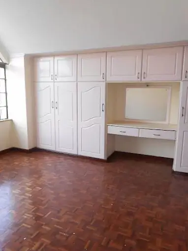 Spacious bedroom with built-in white wardrobes and vanity