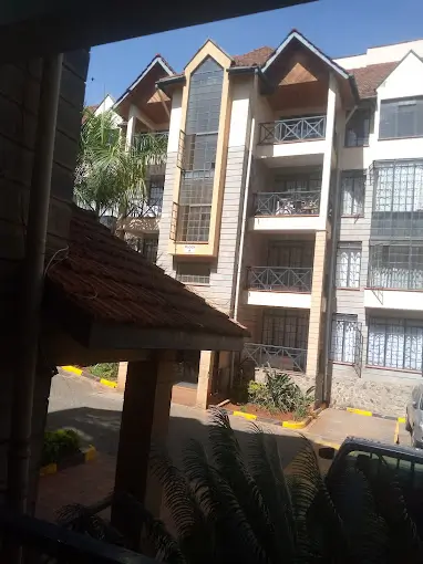 Apartment building exterior view from balcony with landscaping