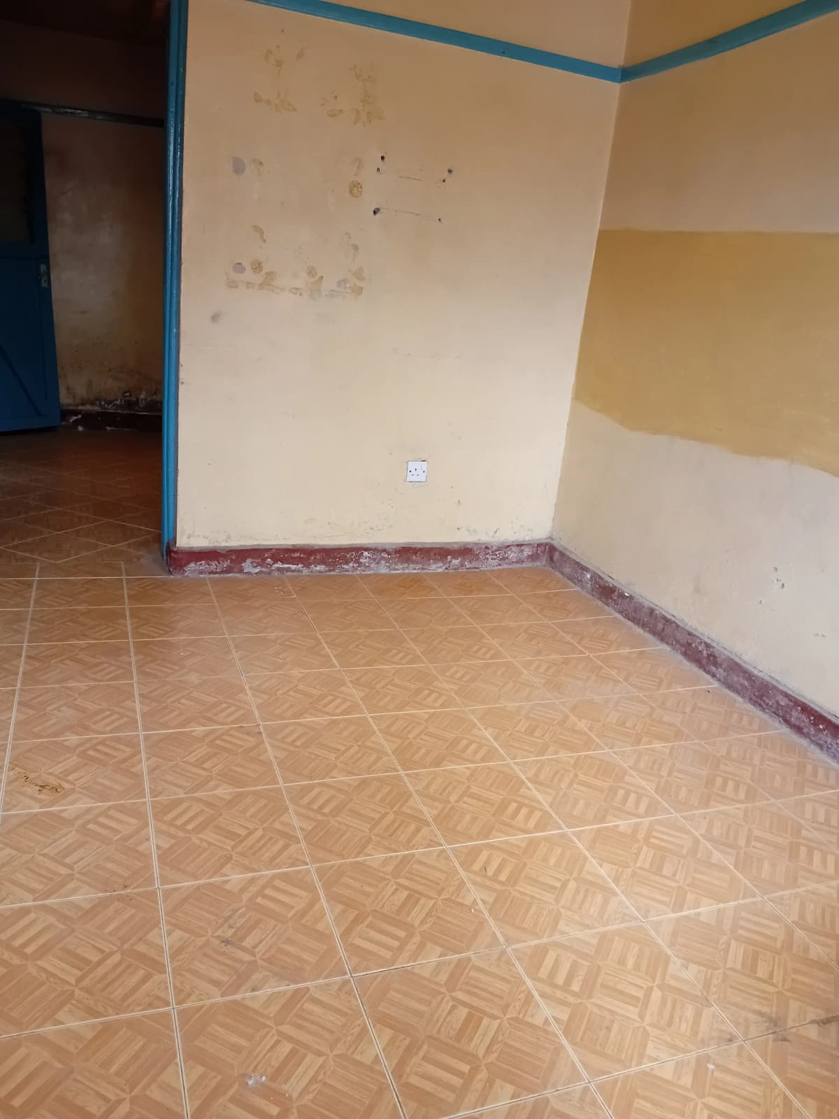 Empty room with geometric tile flooring and blue trim