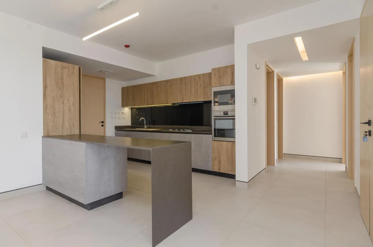 Modern open-plan kitchen with island, black backsplash, wood cabinetry