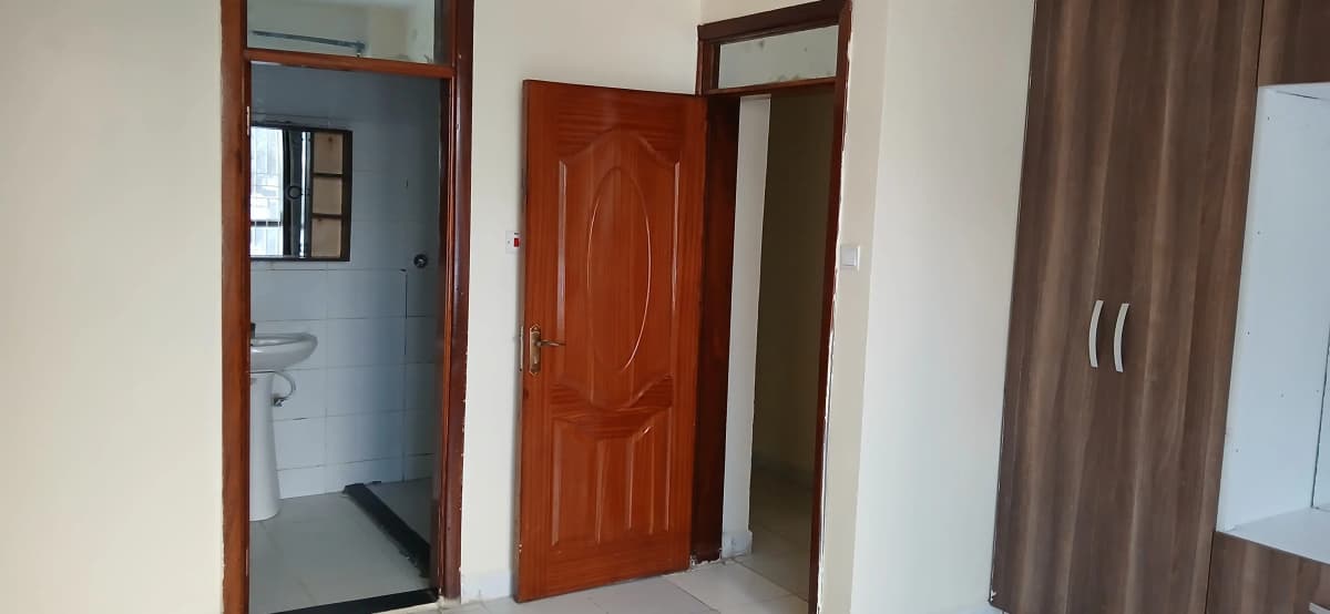 Building corridor with bathroom access and wooden doors