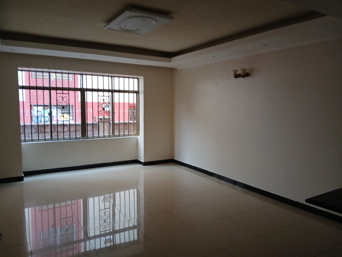 Empty living room with polished floor and barred windows