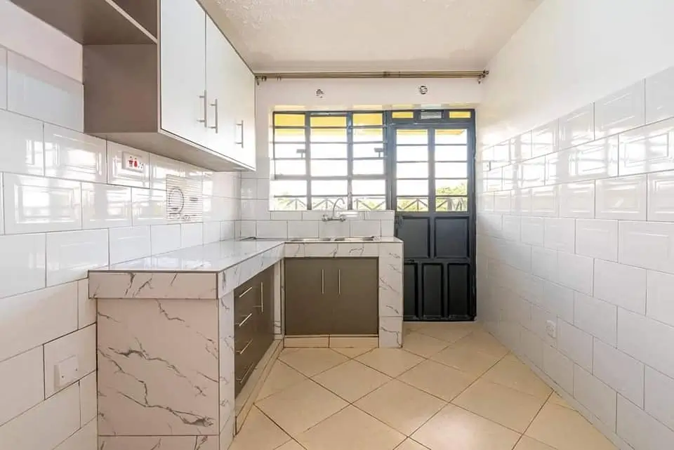 Modern kitchen with marble island, white cabinetry, glass doors