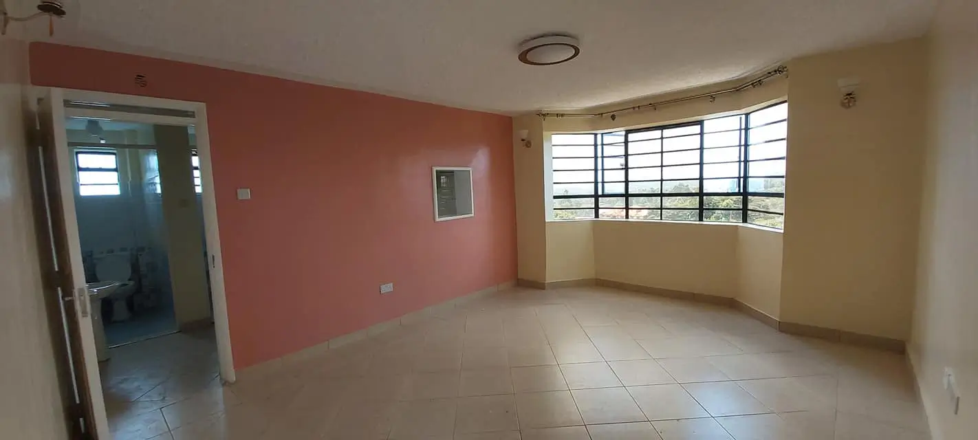 Spacious living room with coral accent wall and natural light