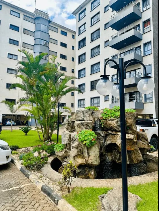 Compound grounds with landscaped garden, palm tree, stone features