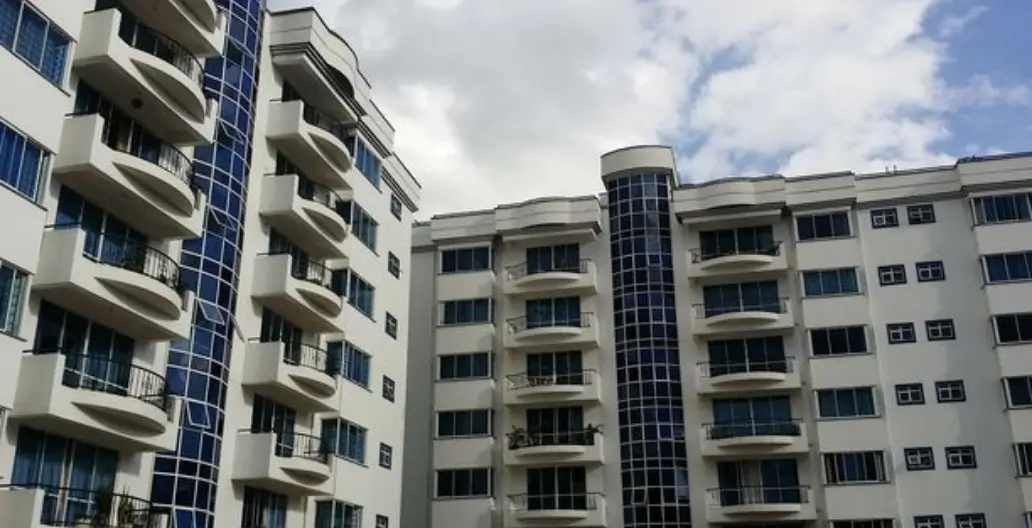 Modern multi-story residential building with balconies and blue accents