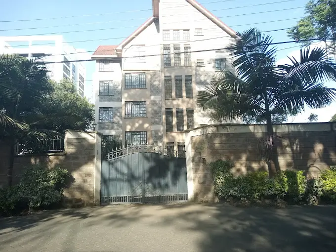 Multi-story residential building with gated entrance and compound