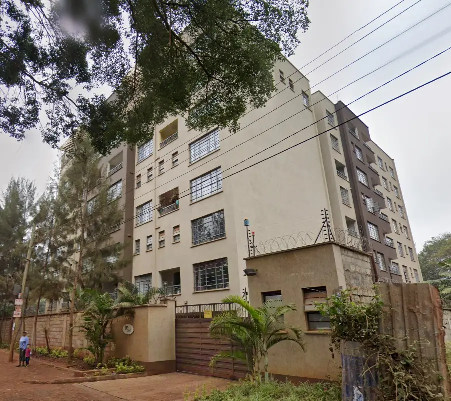 Multi-story residential building with landscaped compound entrance