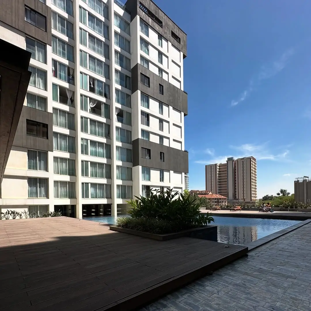 Modern residential complex with landscaped pool deck and water feature