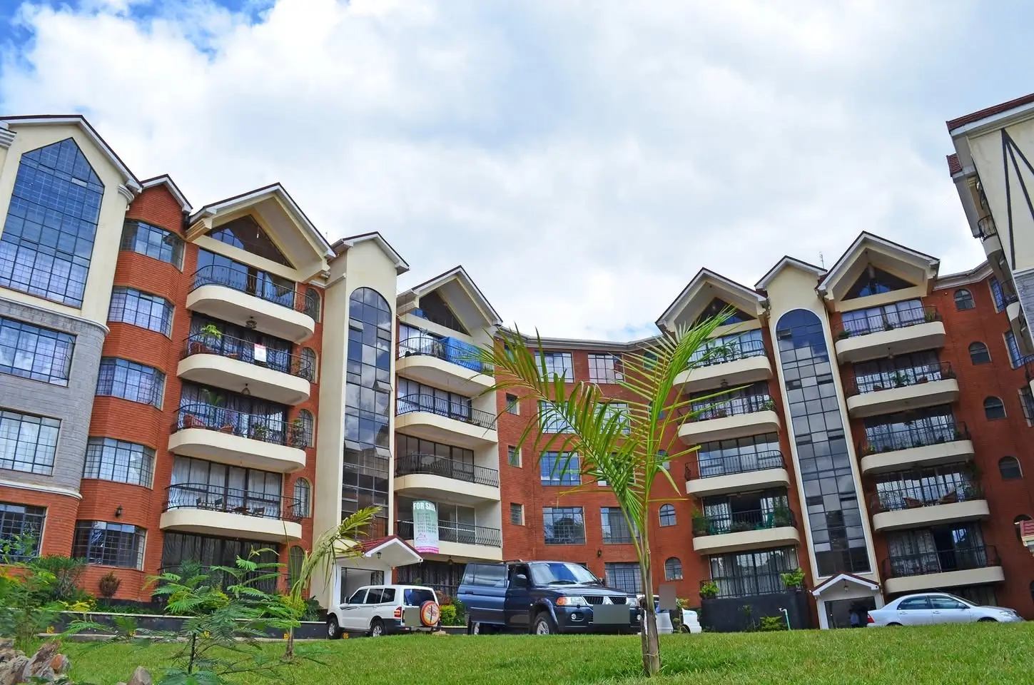 Modern multi-story residential complex with red brick facade