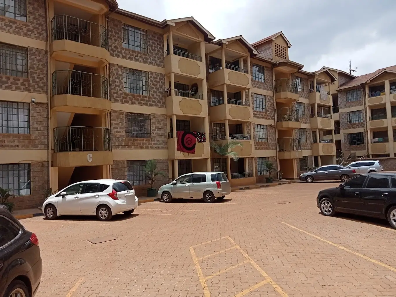 Multi-story residential complex with paved compound parking area