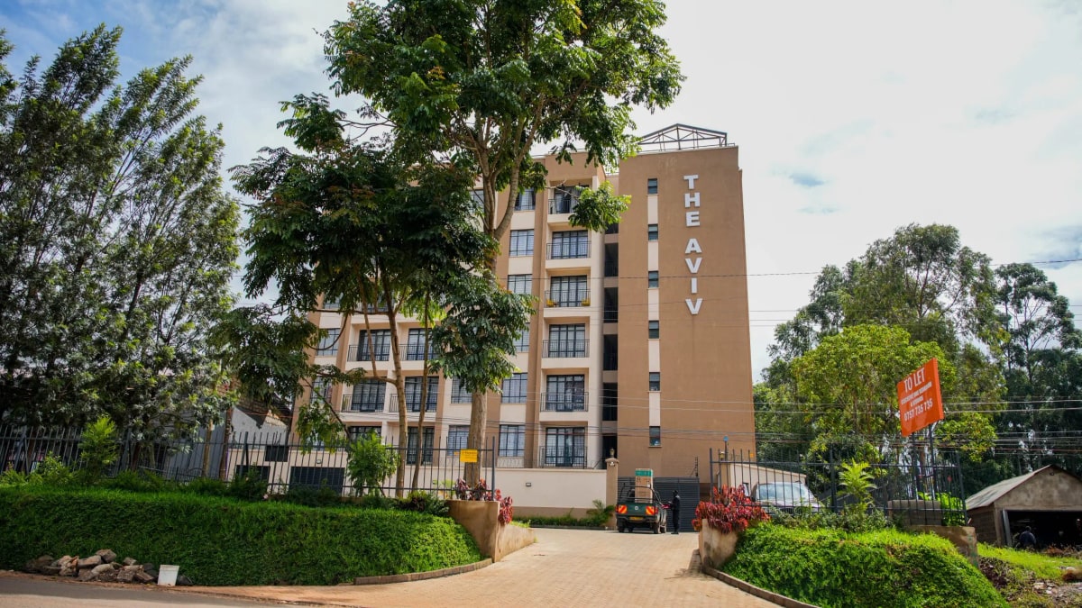 Multi-story residential building with manicured grounds and driveway