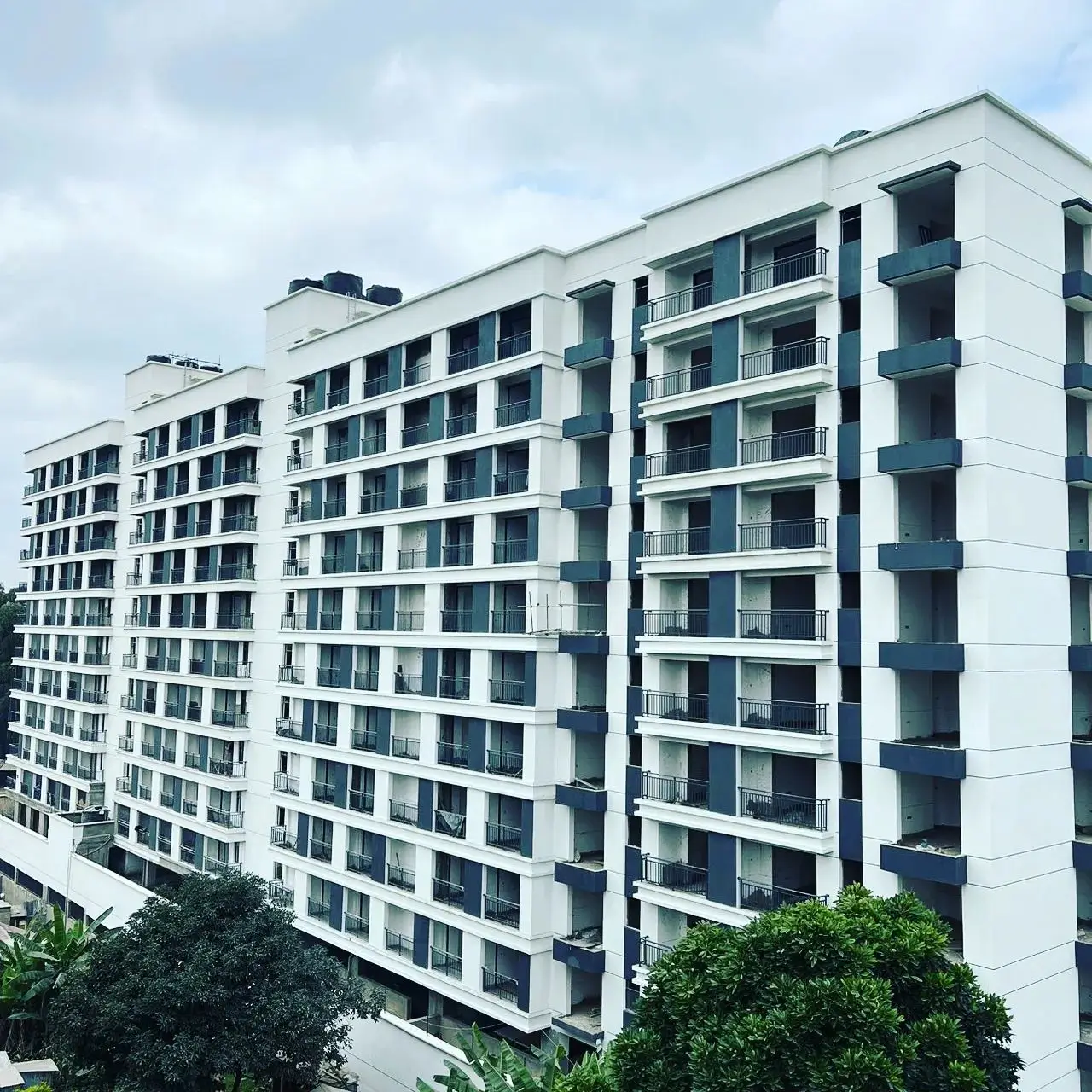 Modern white multi-story residential building with balconies