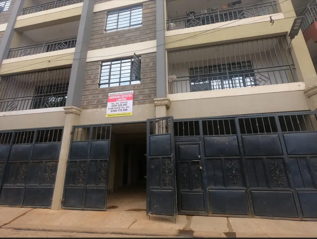 Multi-story residential building facade with black metal gates