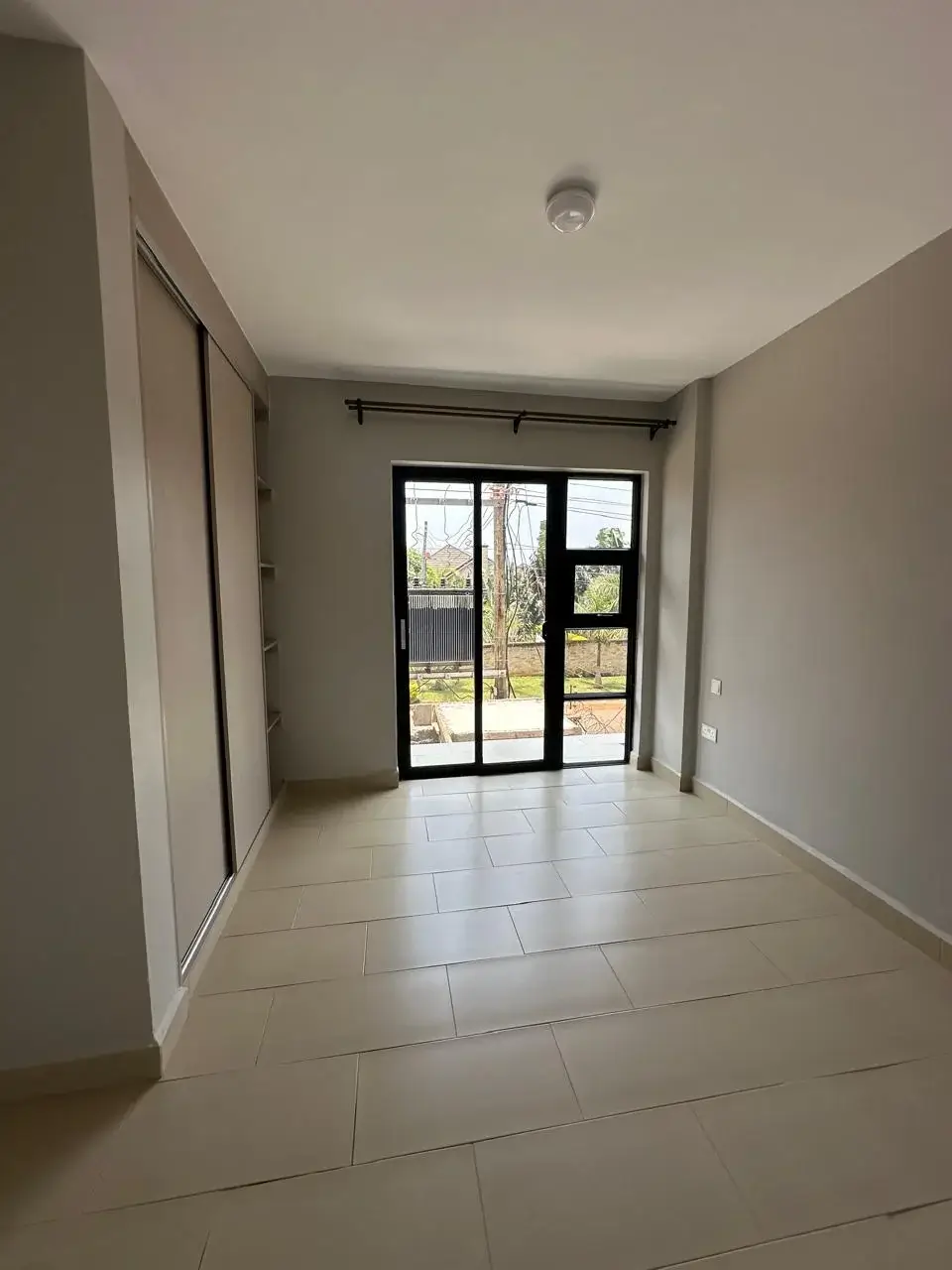 Bright empty living room with glass doors to garden