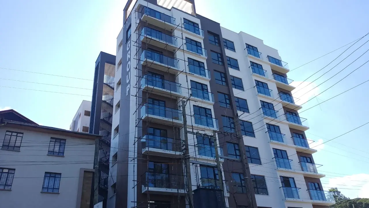 Modern multi-story residential building with blue-tinted balconies