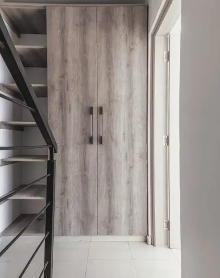 Modern hallway with wooden wardrobe and staircase access
