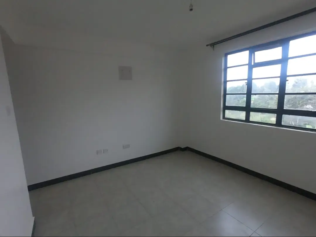 Empty bedroom with large window and polished concrete floor