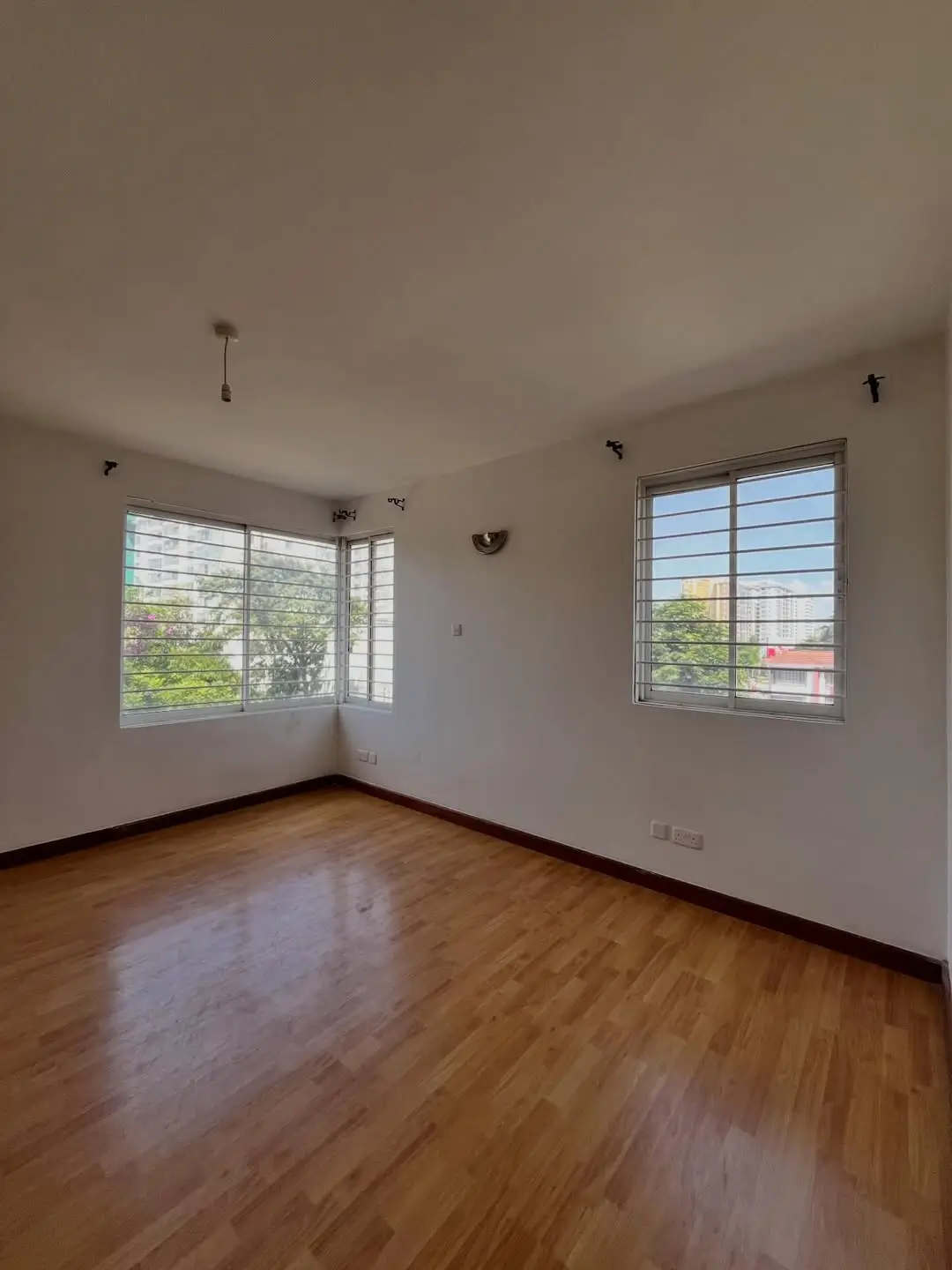 Spacious bedroom with wooden floor and large windows