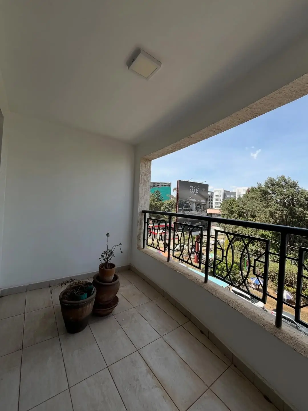Spacious balcony with black railings and city views