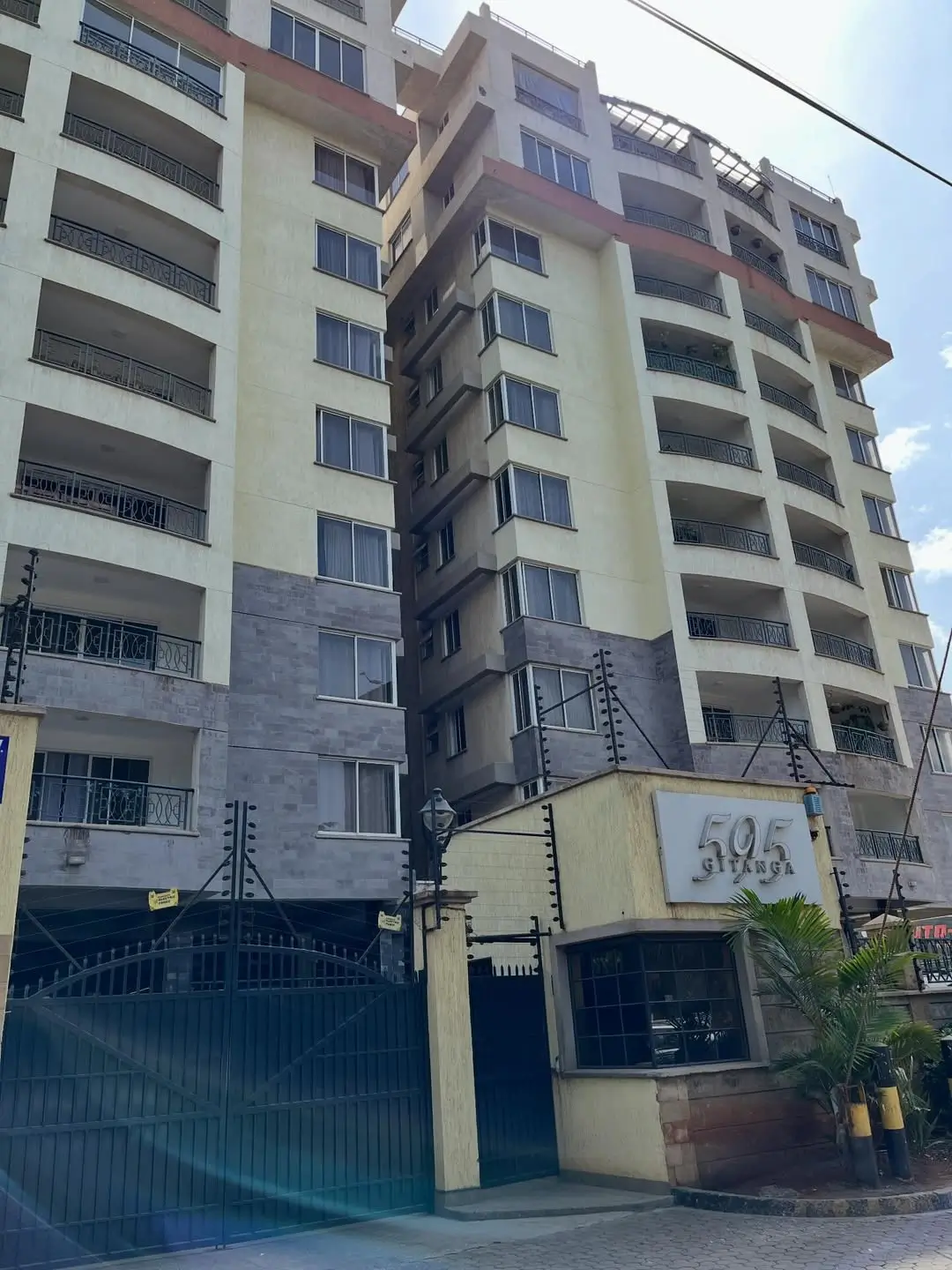 Multi-story residential building facade with ground-floor parking gate