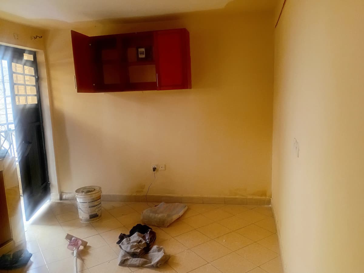 Bare kitchen space with red wall cabinet and yellow walls
