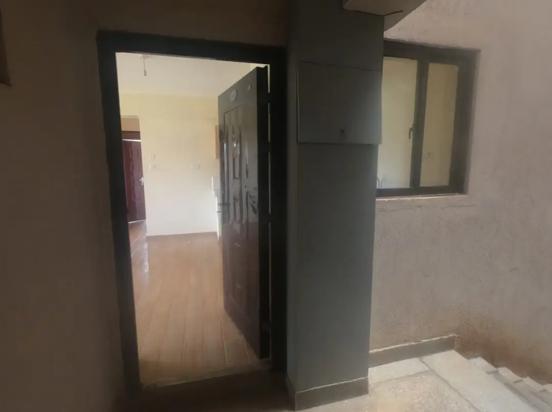 Building corridor with open doorway leading to residential space