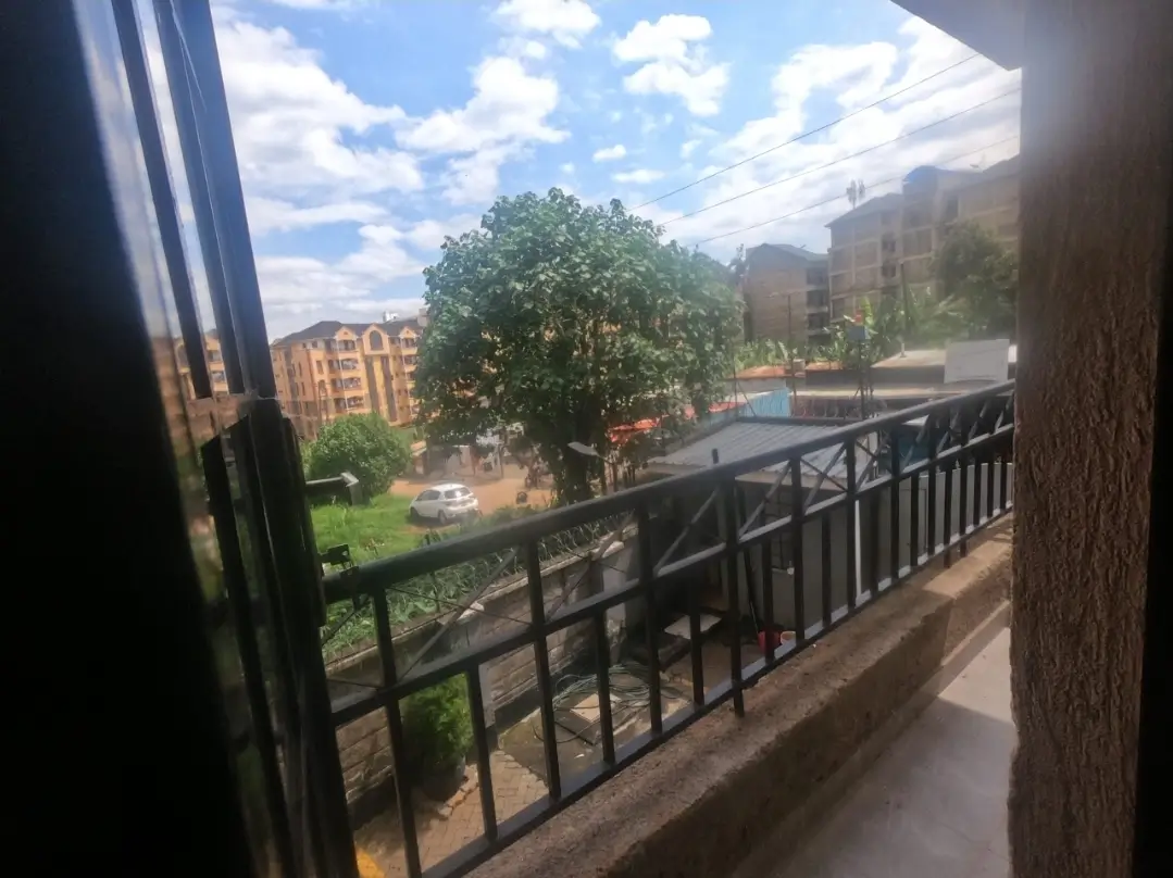 Balcony view overlooking landscaped compound with green spaces