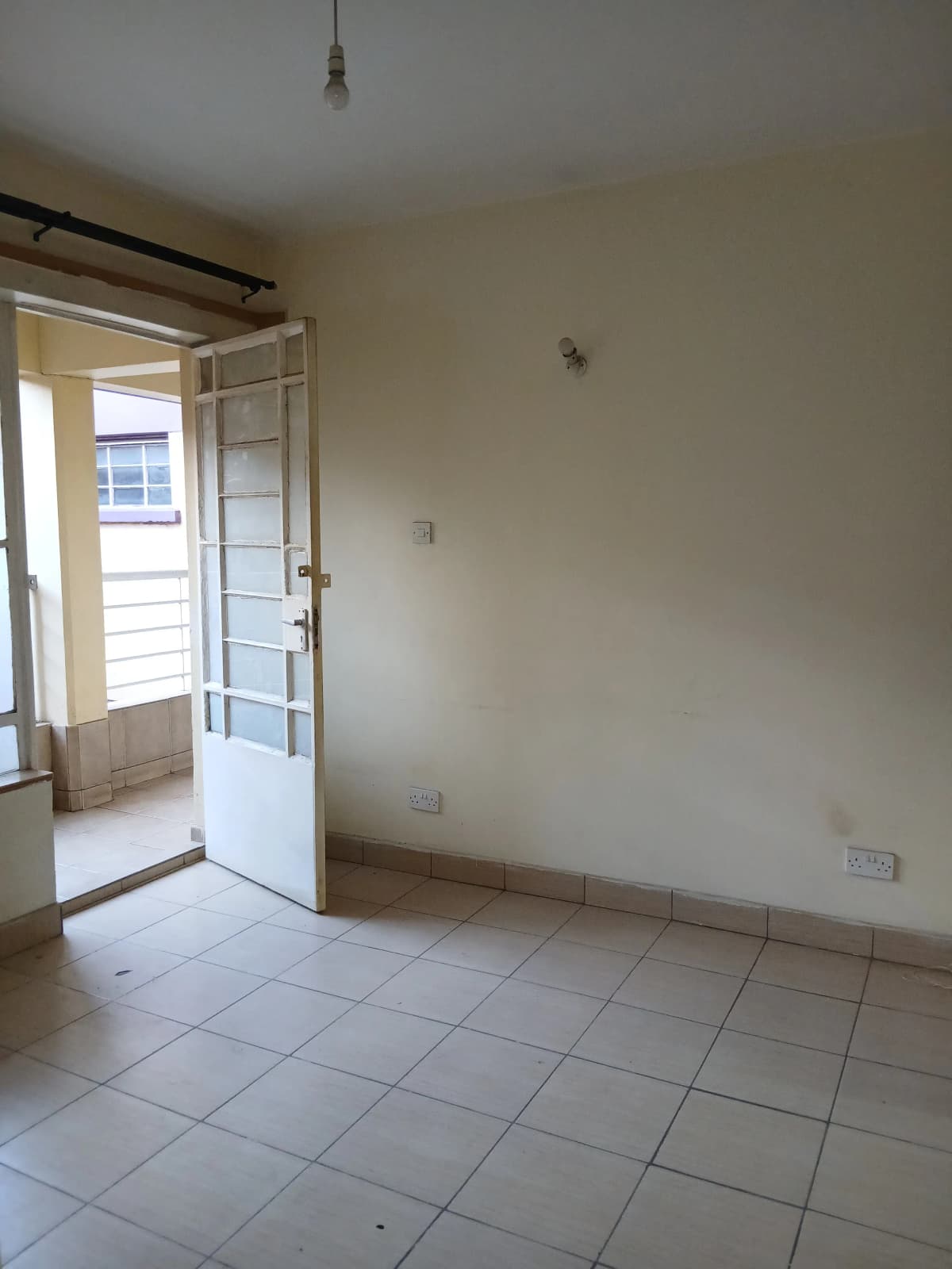Bright corridor with tiled flooring and open door to balcony