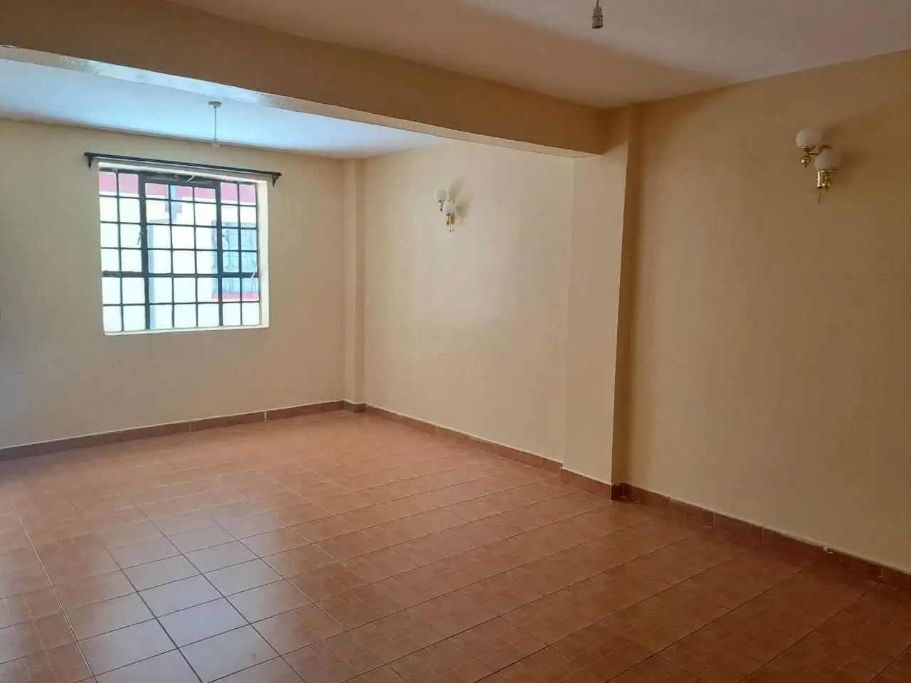 Spacious empty living room with terracotta tile flooring