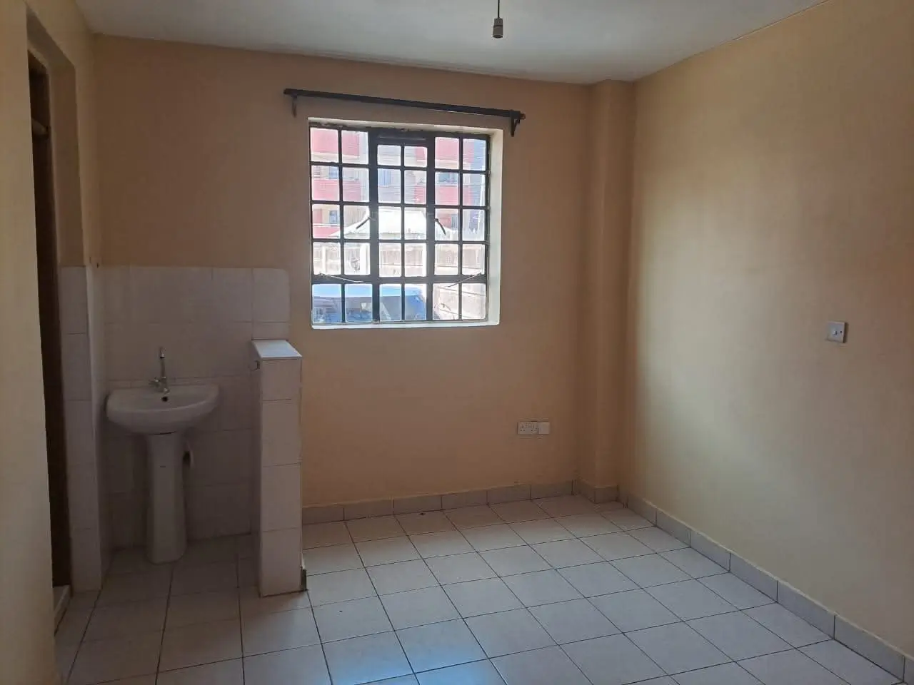 Compact kitchen with sink and basic fixtures, tiled floor