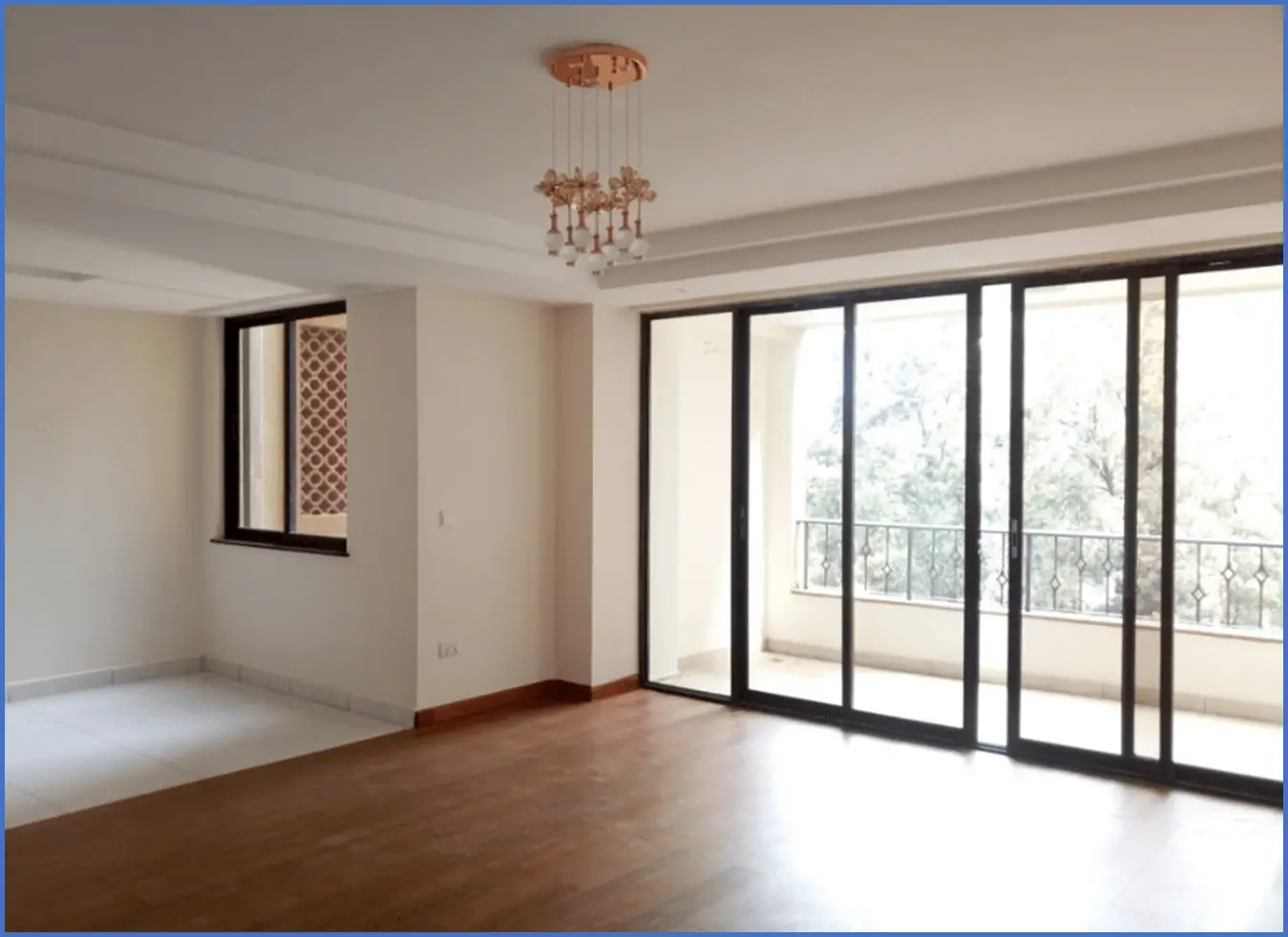 Spacious living room with floor-to-ceiling glass doors opening to balcony
