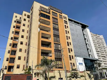 Multi-story residential building facade with balconies and landscaping