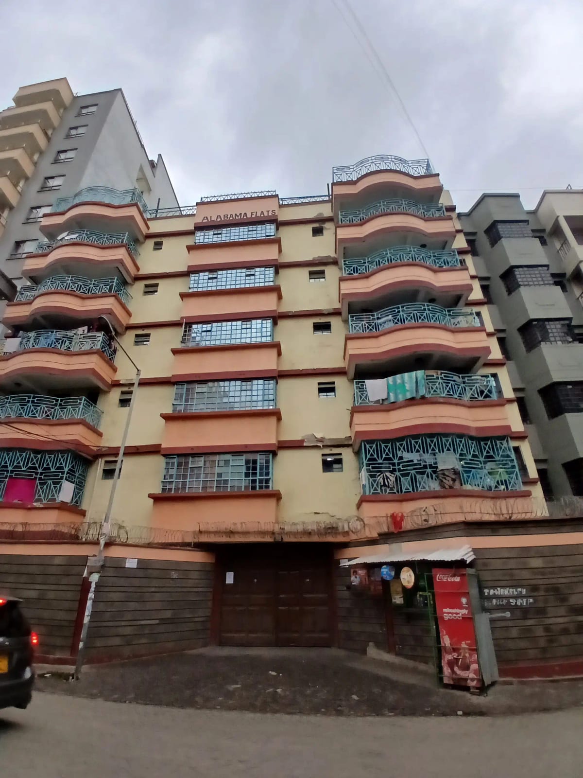 Multi-story residential building facade with balconies and ground-floor retail