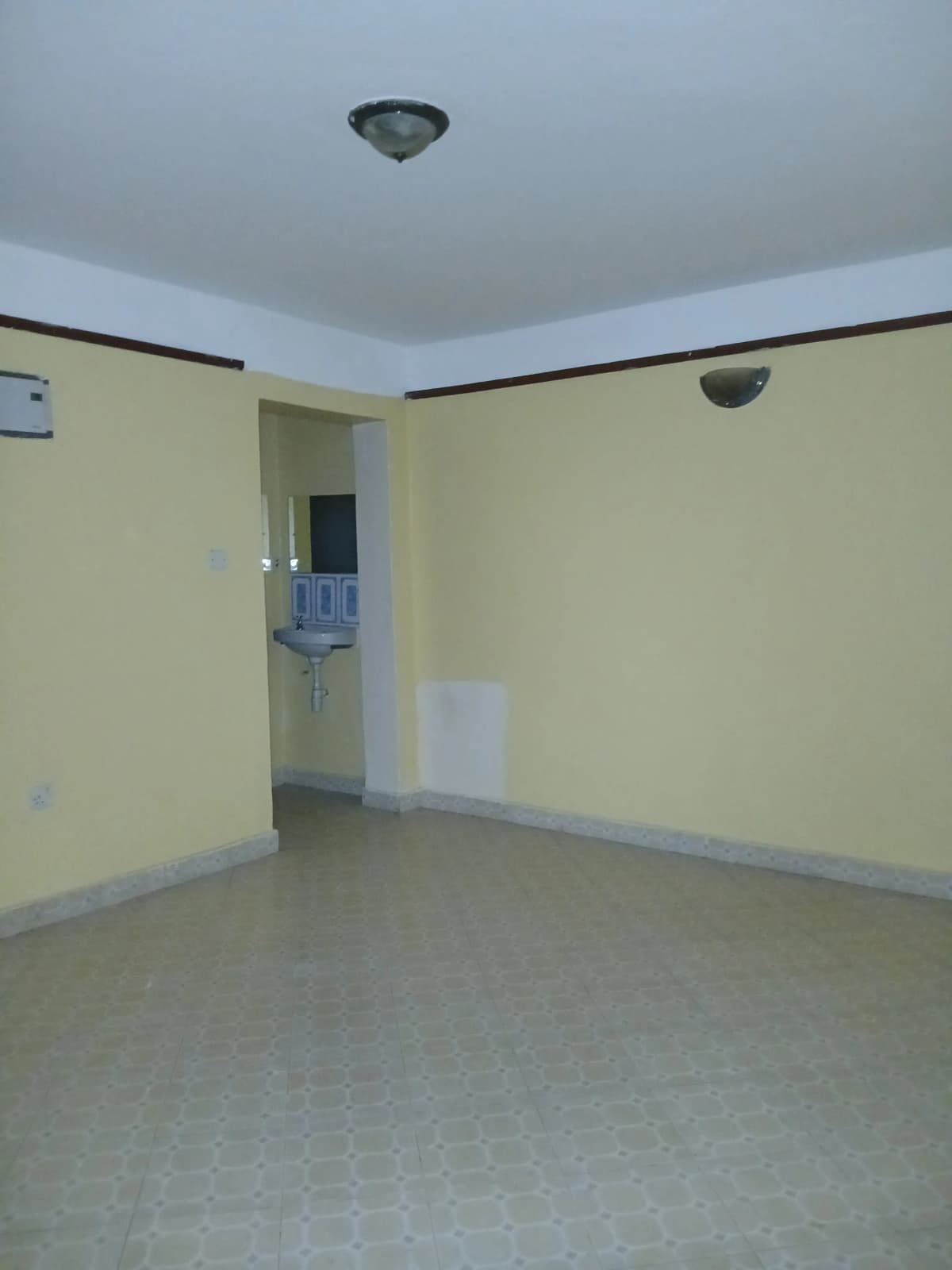 Empty bedroom with yellow walls and polished concrete floor