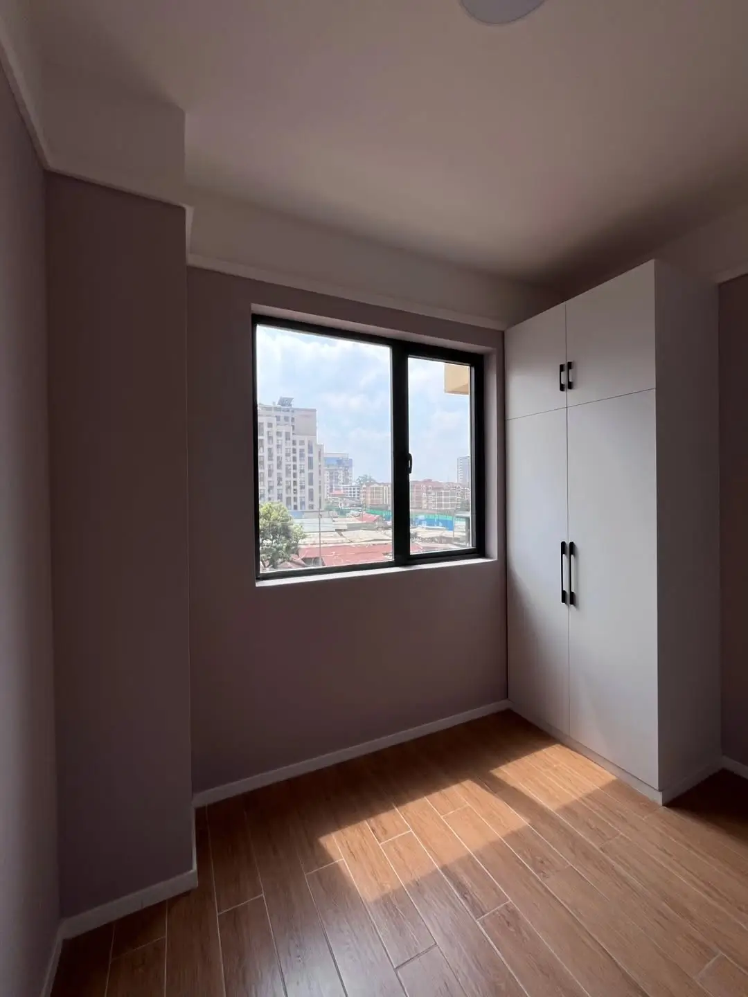 Bedroom with city skyline view through large window