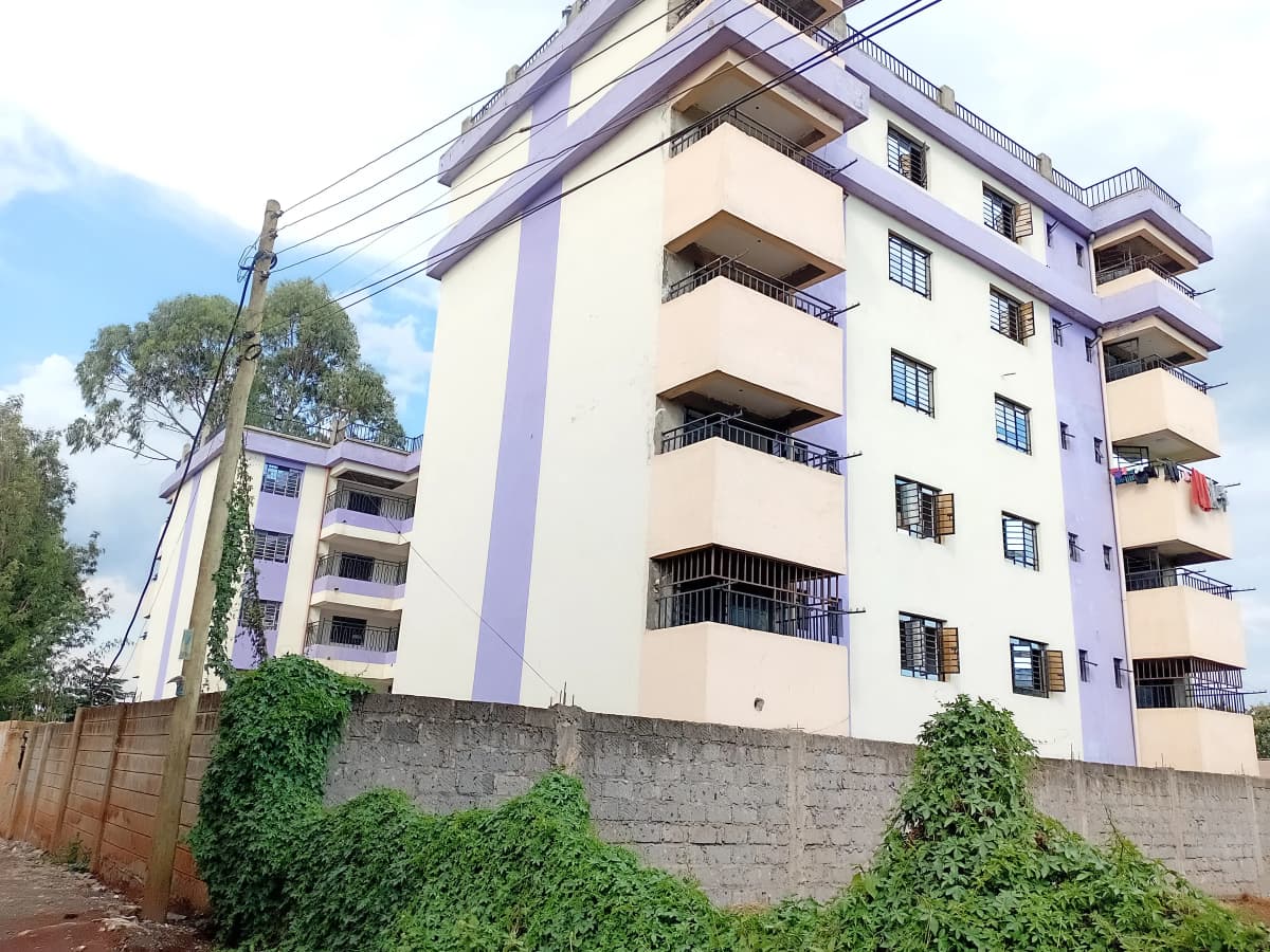 Multi-story residential apartment building with purple and cream facade
