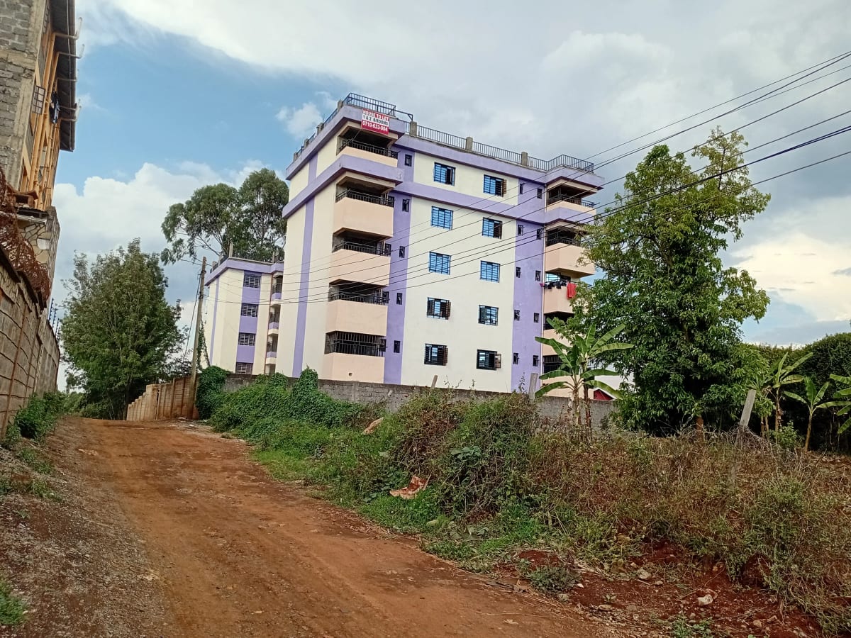 Multi-story residential building with purple facade and balconies