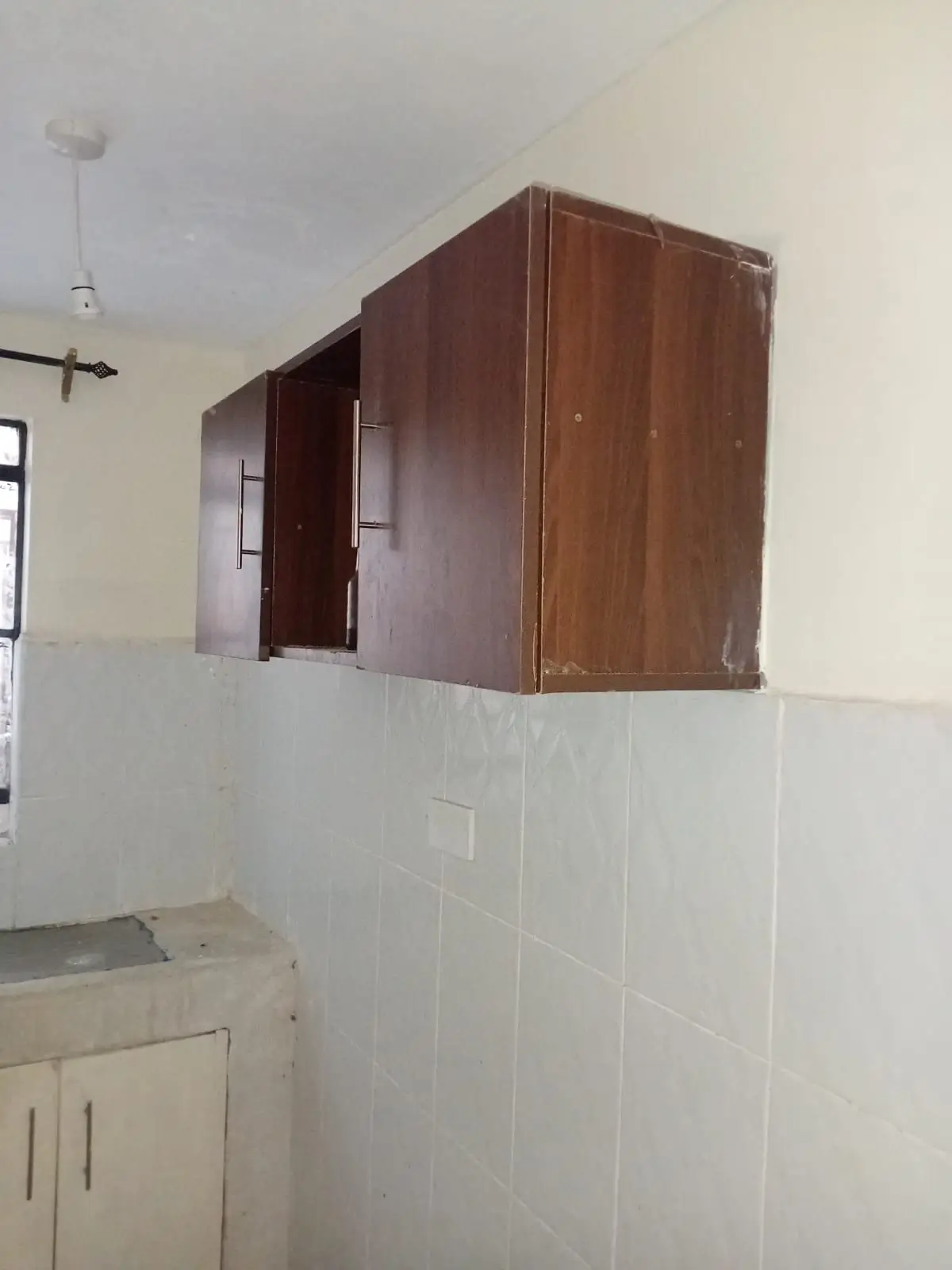 Kitchen with wall-mounted wooden cabinets and sink unit