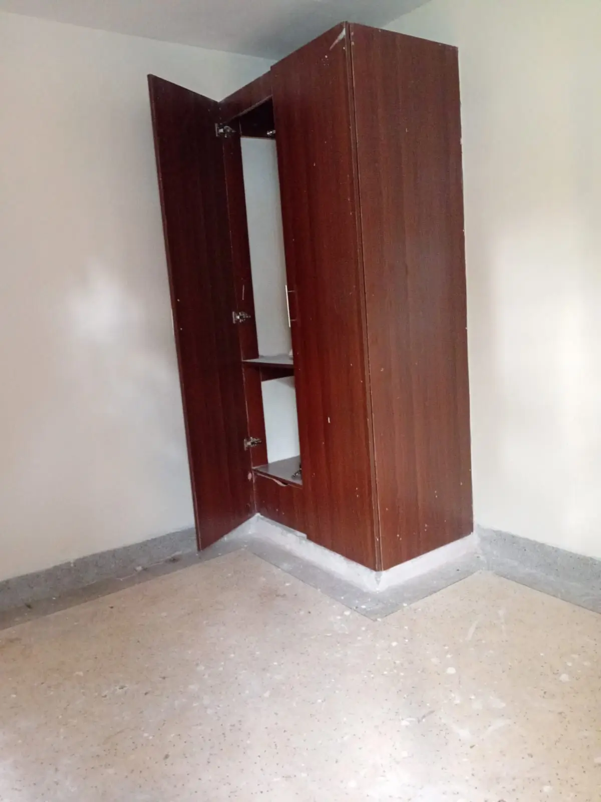 Empty room with maroon wardrobe cabinet and bare floors