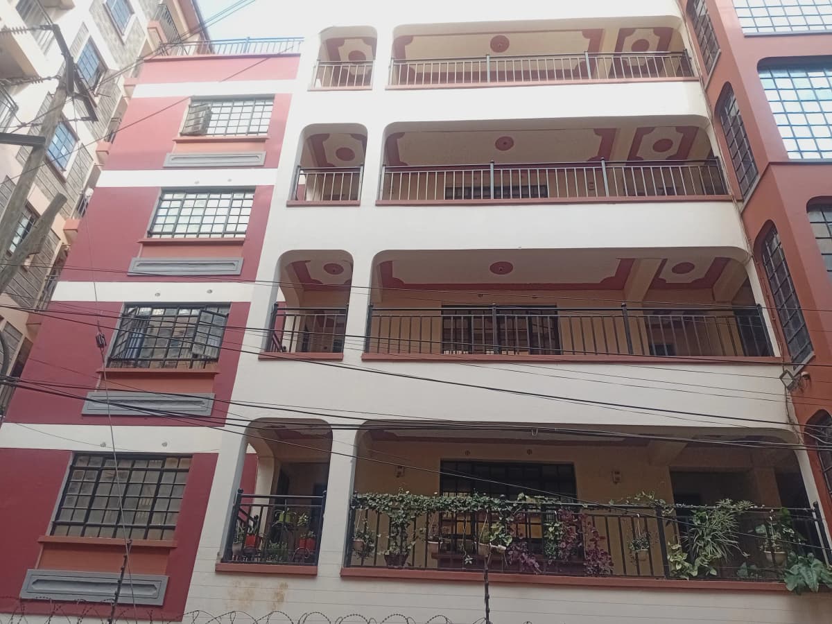 Multi-story residential building facade with balconies and plants