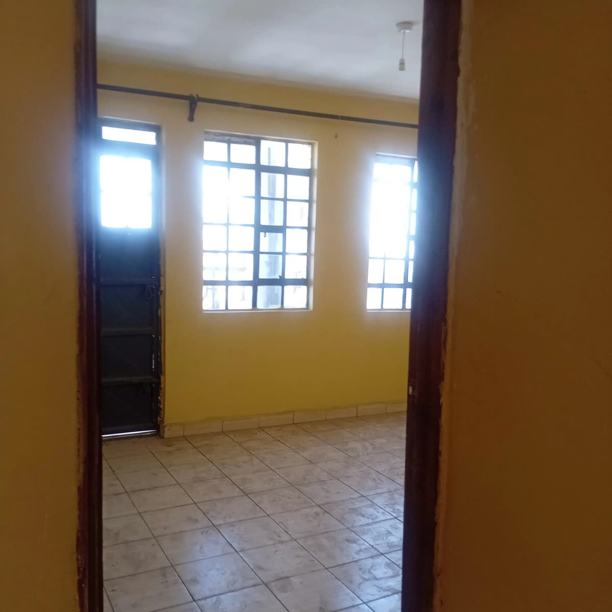 Bright living room with yellow walls and tiled flooring