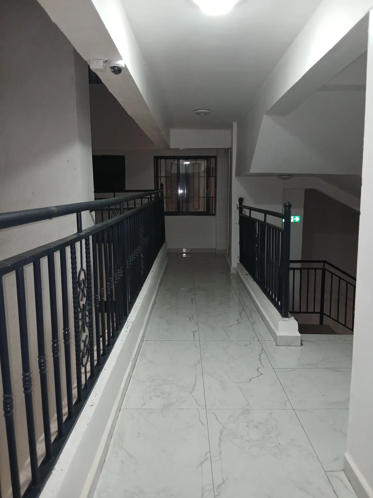 Modern corridor with marble flooring and black railings