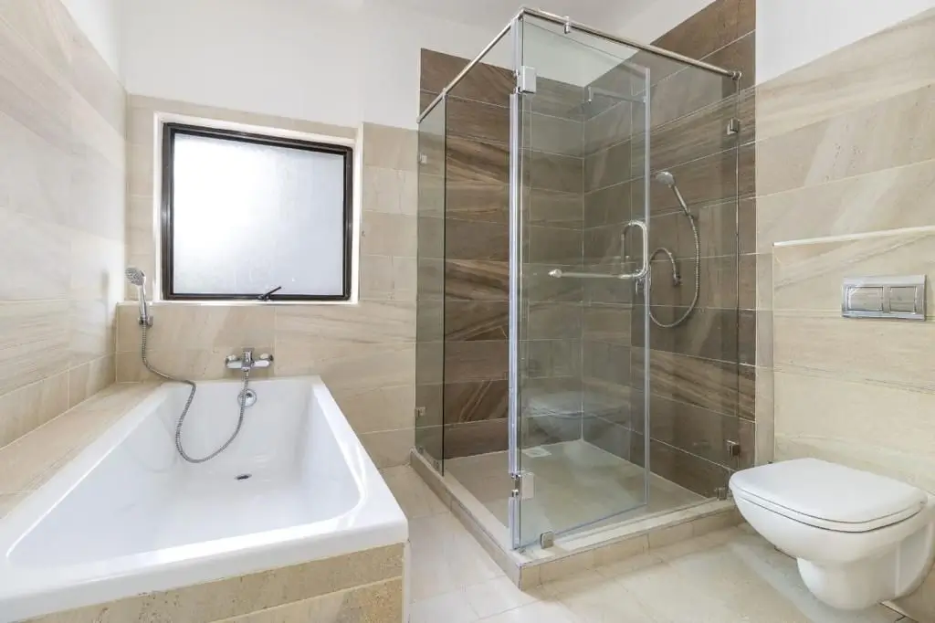 Modern bathroom with bathtub, glass shower enclosure, toilet