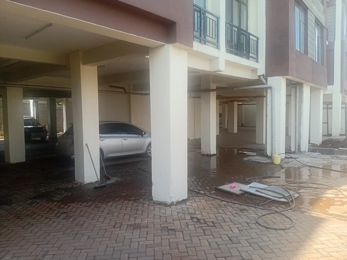 Covered parking area with brick flooring and support columns
