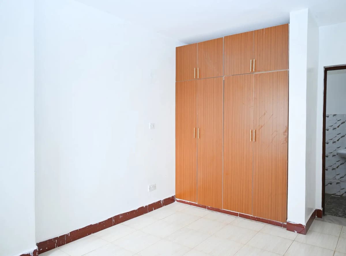 Empty bedroom with wooden built-in wardrobe